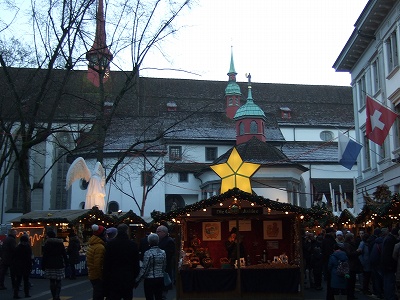 多くの人々がスパイス入りホットワイン（グリューヴァイン）で温まりながらマーケットを楽しんでいるよう。