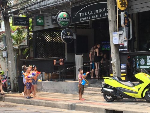 みせの中に向けて水を掛ける子供たち