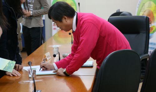 参加者のサインに応じる主催者の李永然（リー・ヨンラン）弁護士