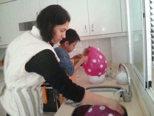 瓶やボールで風船を固定して糊水をくぐらせた新聞紙を貼ります。新聞紙は2重にすると強度が適度です。