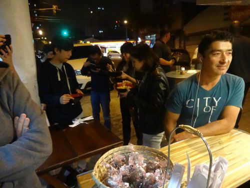 フードトラックのラーメン屋『ラーメンＫ』でラーメンを立ち食いする人々