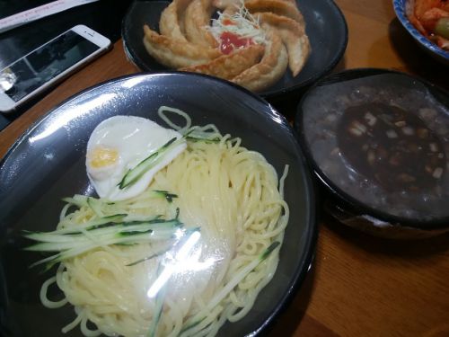 目玉焼きの乗った麺。奥はサービスの揚げギョーザ、数人前以上でこうしたサービスがつきます