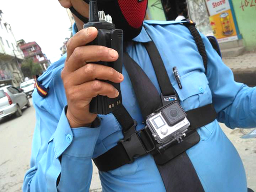 無線機片手に、胸にはカメラ
