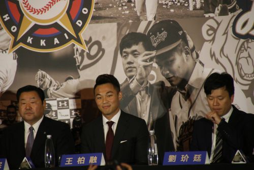 会見の席に着き、笑みを浮かべる王柏融（中央）