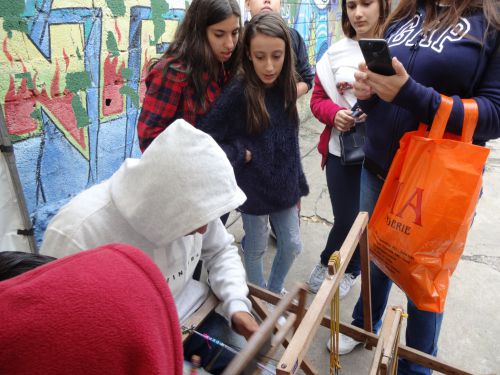 ミサンガを製作するブラィアンさんと完成を待つお客さんたち