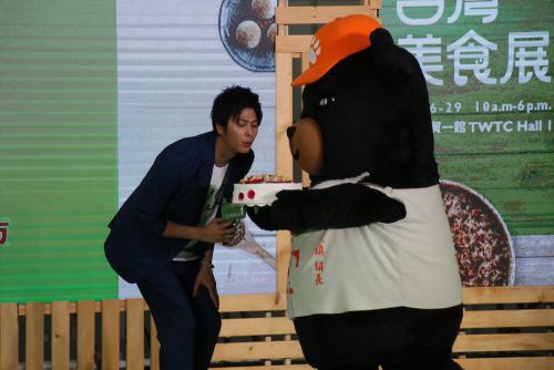 ろうそくの火を消す速水もこみちさん(左)、右は台湾観光局のマスコット「Oh! Bear(オーベア)」