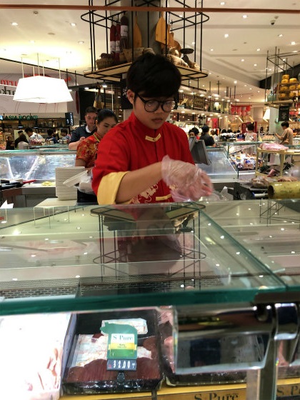 肉屋の店員さんも中国服で仕事中