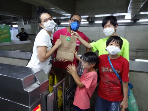 『ノッサ・ジャネーラ（Nossa Janela）』に注文したパンを改札口で受け取る様子