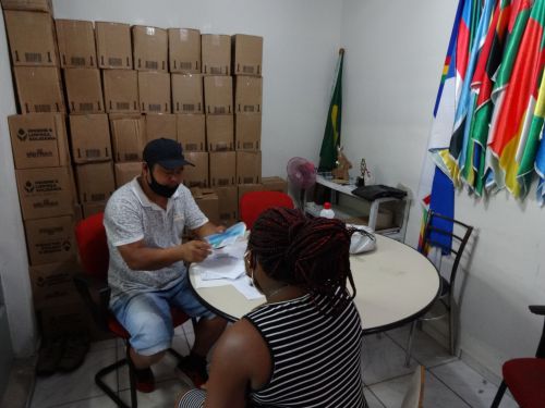 NGOアフリカ・ド・コラソンの事務所でフードカードの説明を行う職員