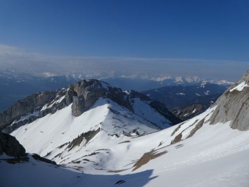 青空の中、遠くに連なる山々と目前の雪山が一度に視野に入り、圧倒されます