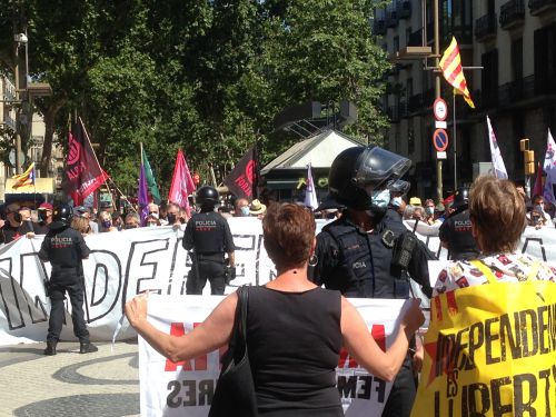 警察の非常線の前で「占領軍と一緒に！」「恩赦と自由」などのスローガンを唱える民衆。
