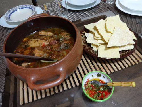 土鍋に盛り付けられたダモリーダとベイジュー（せんべい状の食べ物）