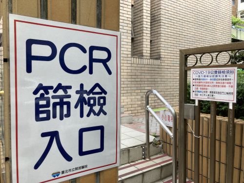 検査場につながる病院の入口（身分証と保険証が必要で、どちらかが欠けても検査を受けられない旨が記されたものも貼られています）