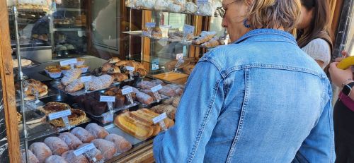 シャッターを閉め始めたパティスリー店のウインドーを眺め、買いたそうな観光客ら
